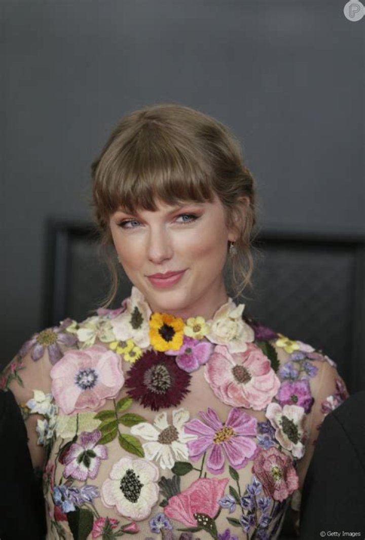Taylow Swift aposto em penteado preso com fios desconectados e